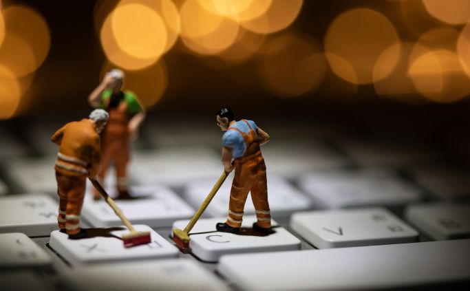 Miniature figures sweeping the keys of a keyboard.