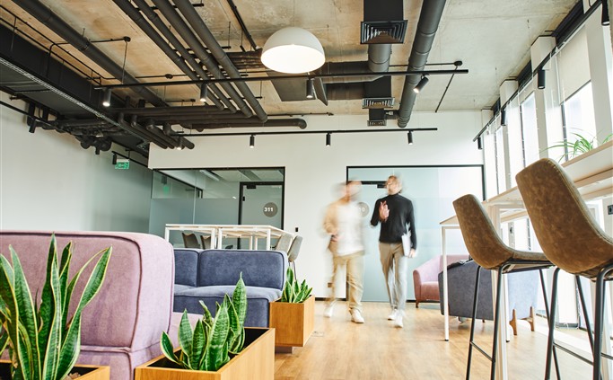 Bright office space with seating and people in the background.